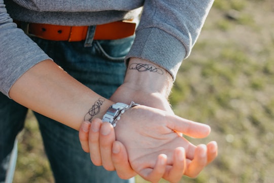 couple with simple matching tattoos inside the wrist