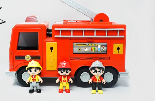 Ryan's World Mystery Fire Truck: Three toy figurines standing in front of a red fire truck