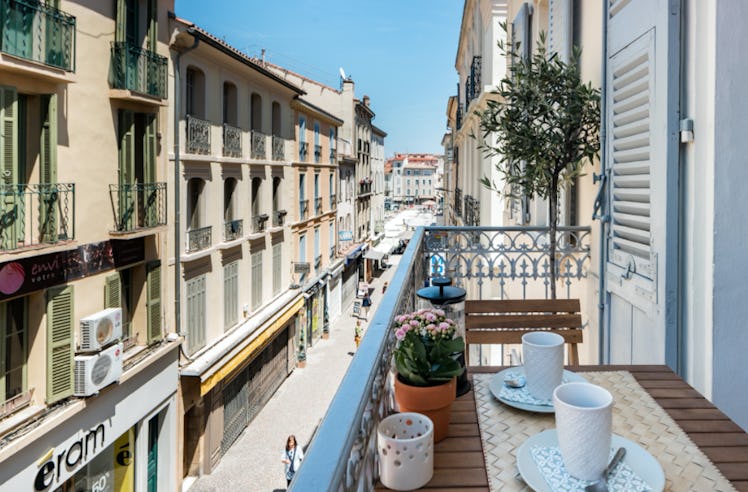 The balcony of an Airbnb in the French Riviera has beautiful views of the colorful buildings and nei...