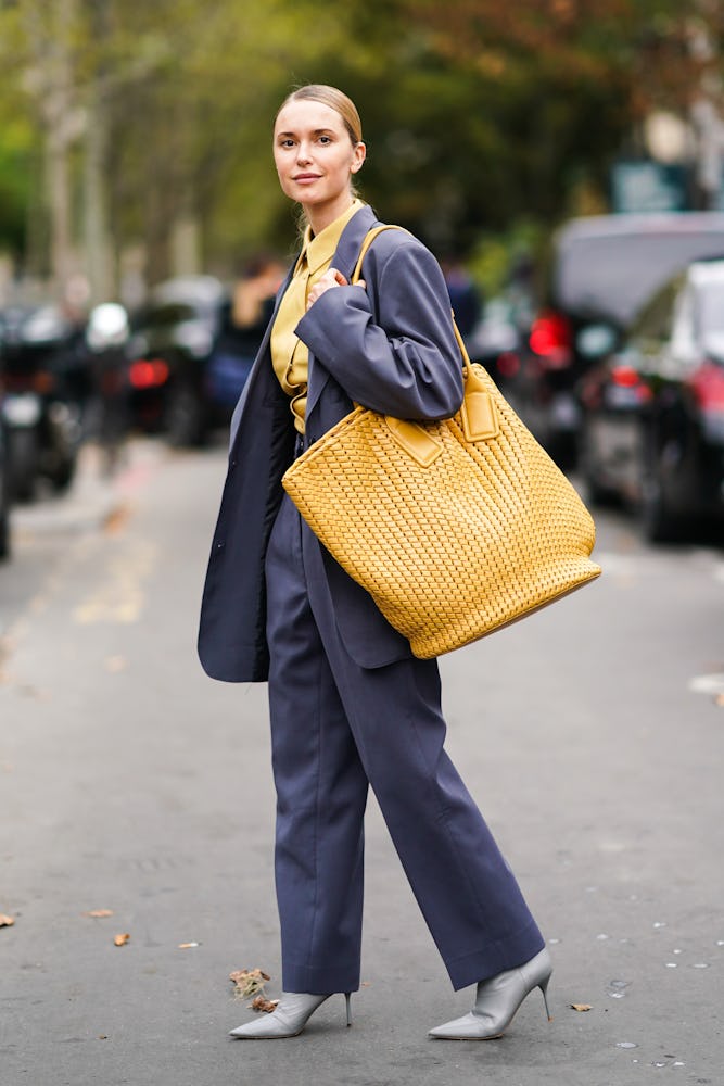 Street style photo of influencer Pernille Teisbaek carrying an oversized Bottega Veneta bag at Paris...