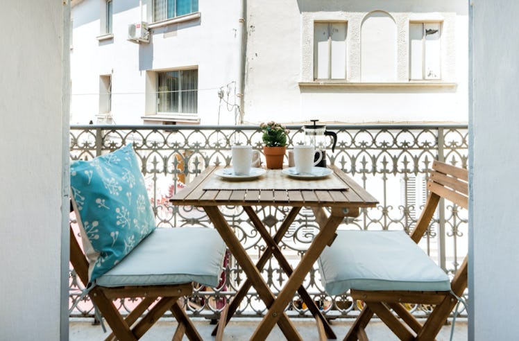 The balcony of an apartment in Antibes has a table with two chairs and is a great spot for enjoying ...