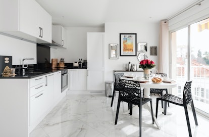 The kitchen of an apartment in Cannes is decorated with black and white details and is the perfect s...