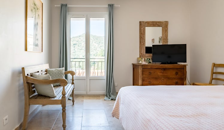 A bedroom in an apartment in Bormes-les-Mimosas is cozy and made for a couple's getaway.