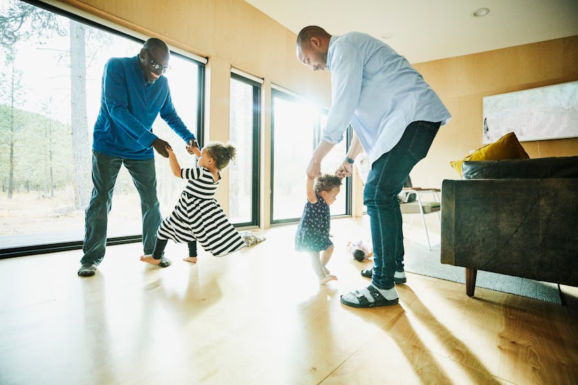 Grandpa and grandchildren play in living room.