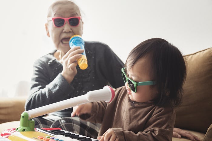 a grandmother sings on a microphone while her grandaughter plays keyboard.
