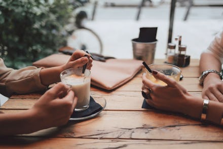 Two friends drinking coffee and joking.