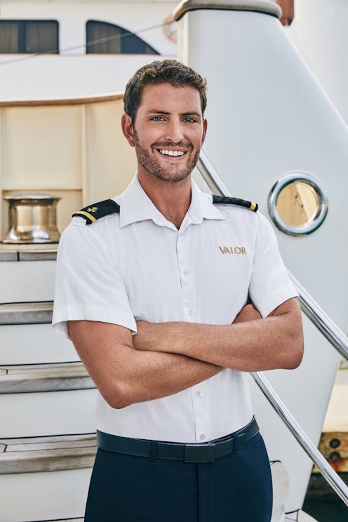 Tanner from 'Below Deck' Season 7 poses in front of a yacht.