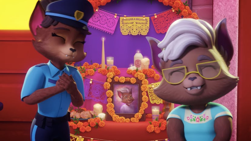 A police cat and a grandma cat standing in front of an ofrenda for Dia de los Muertos