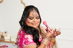Nabela Noor poses with the Nabela Noor x e.l.f. Cosmetics collection