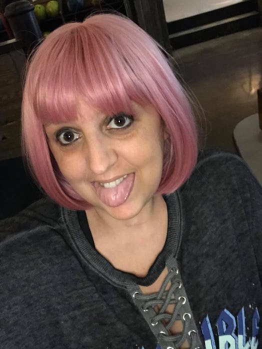 Woman in pink wig sticks out tongue.