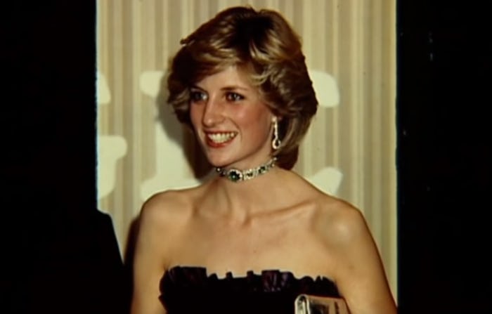 Princess Diana smiles in a black dress