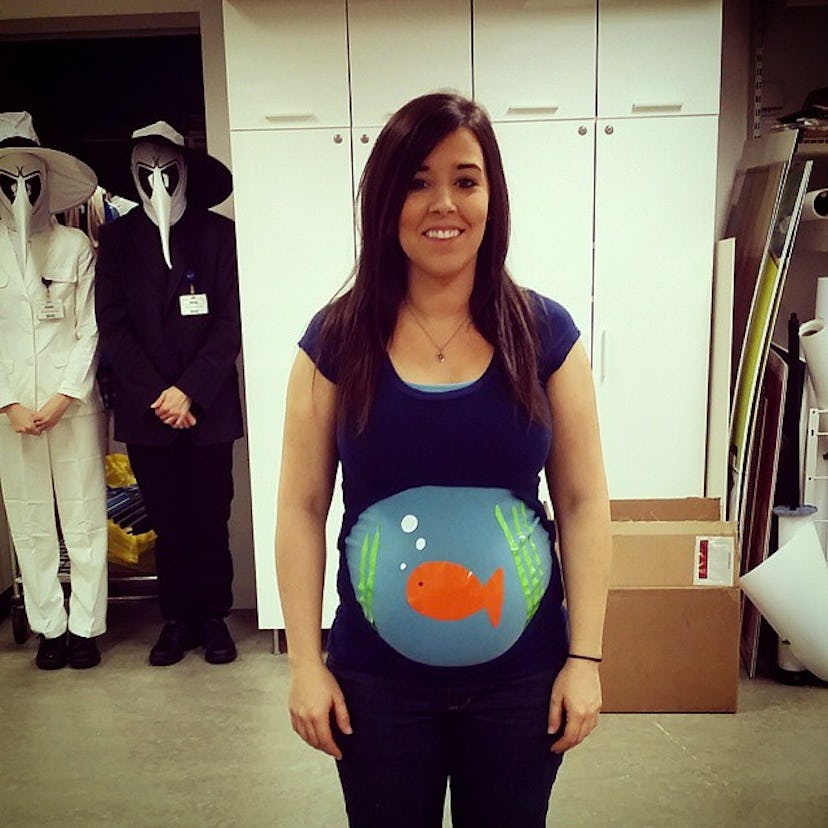 A pregnant woman wearing a fishbowl Halloween clever maternity costume