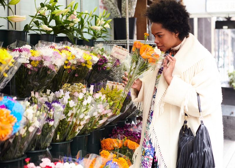 A woman sniffing flowers, enjoying being alone