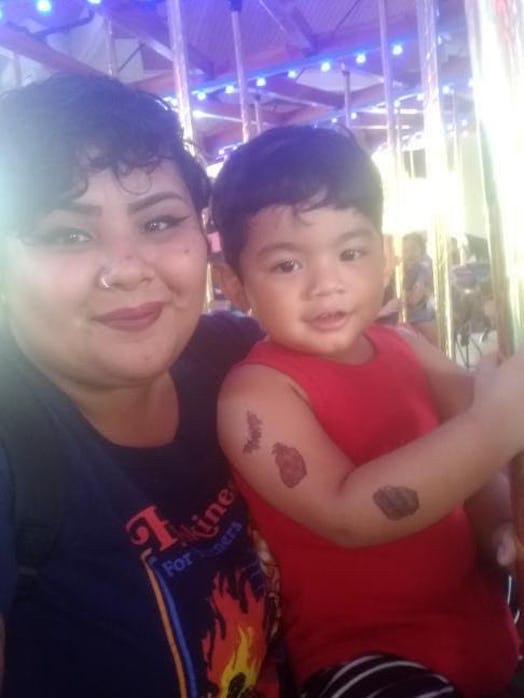 A mother riding a carousel with her toddler