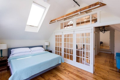 The bedroom of a pet-friendly loft apartment in Kennebunk, Maine has a skylight and comfortable bed.