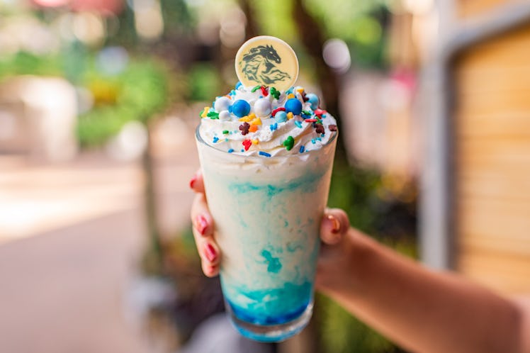The Elsa’s Frozen Wave milkshake with whipped cream and colorful sprinkles is available at Disney in...
