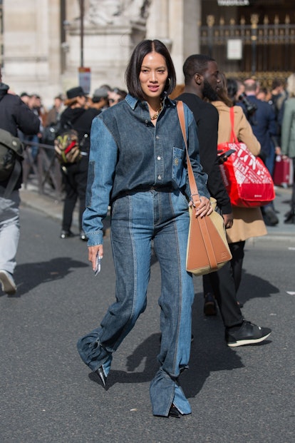 A woman walking down a street in a denim jeans and shirt combination