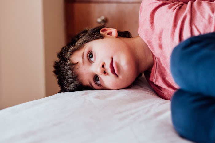 Boy lies in bed pretending to be sick