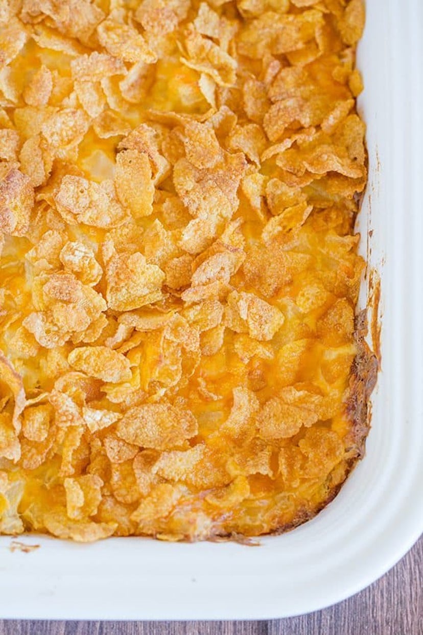 Easy Thanksgiving dishes; baking dish full of cheesy potato casserole with corn flake topping