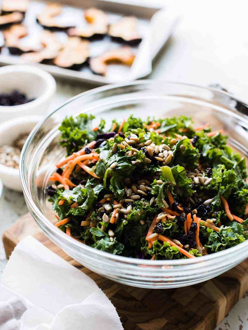 Easy Thanksgiving dishes; bowl of roasted acorn squash and kale salad on a cutting board