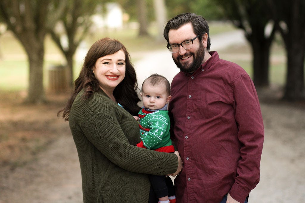 parents and a baby posed for a family portrait