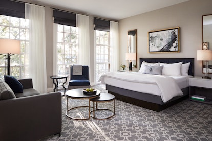 A modern hotel room is decorated with white, black, and gray decor at The Whitney in Boston.