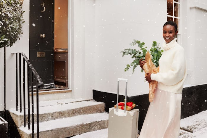 A woman standing in the snow wearing a sweater and skirt from H&M's Black Friday sale
