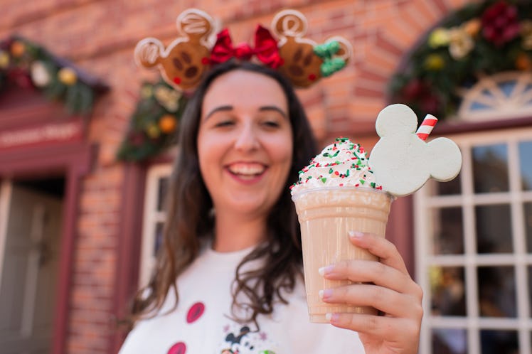 A woman holds a holiday milkshake at Mickey's Very Merry Christmas Party.