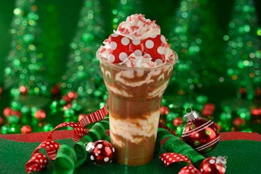 A festive float with whipped cream and red Minnie ears on top is surrounded by holiday decorations, ...