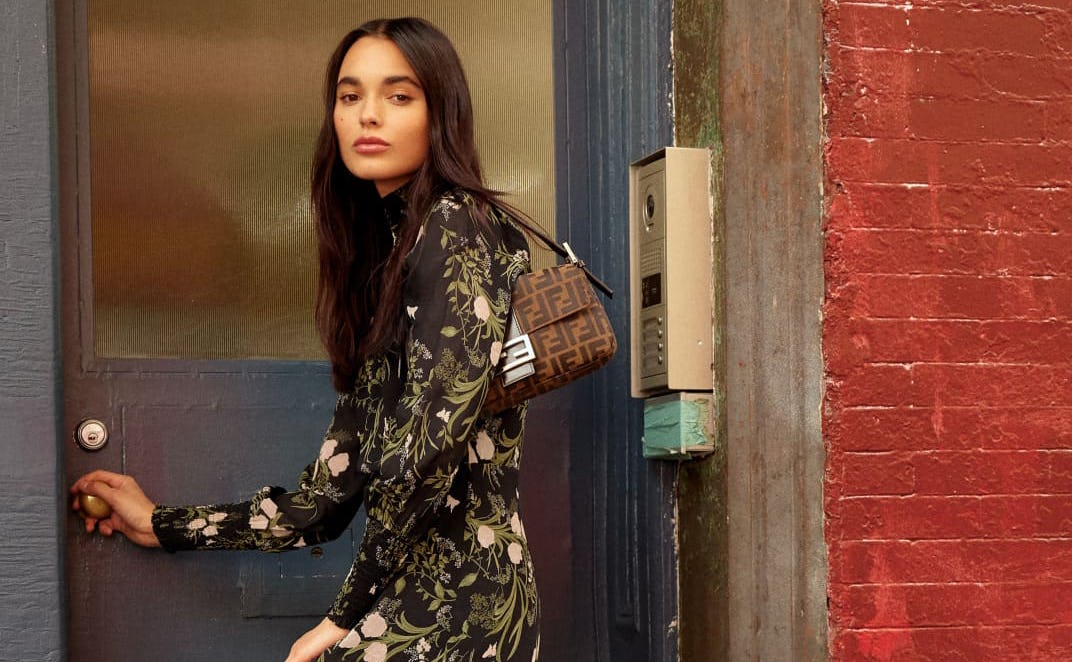 A woman entering a building wearing a Valentin Dress from reformation bought at the black friday sal...