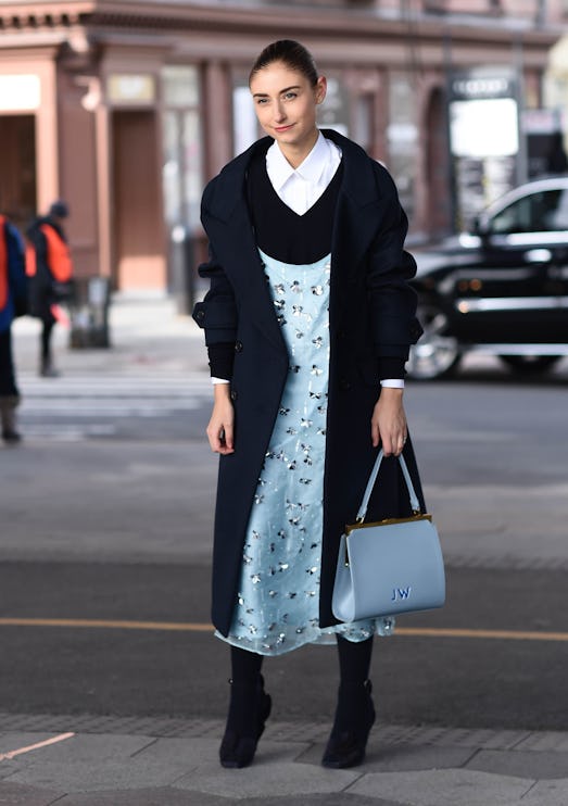 Street style photo of Jenny Walton wearing a blue Tory Burch dress layered over a black sweater and ...