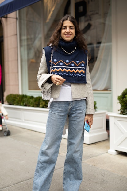 Street style photo of Leandra Medine wearing a sweater vest and blazer with jeans at New York Fashio...