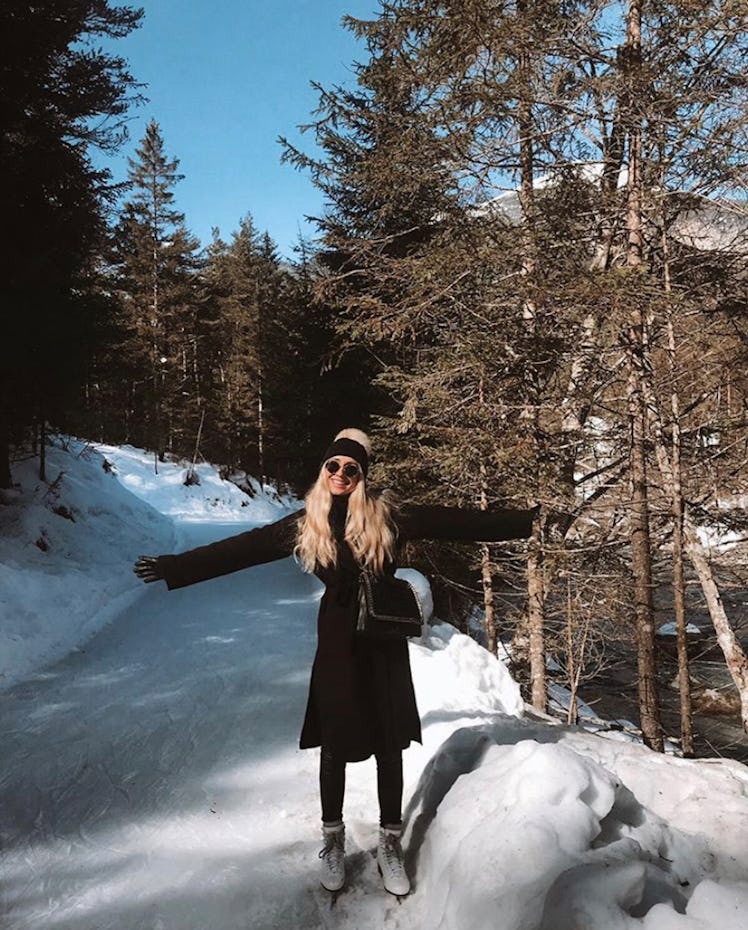 A blonde woman poses on the ice skating path at Skateline Albula in Switzerland on a sunny day.