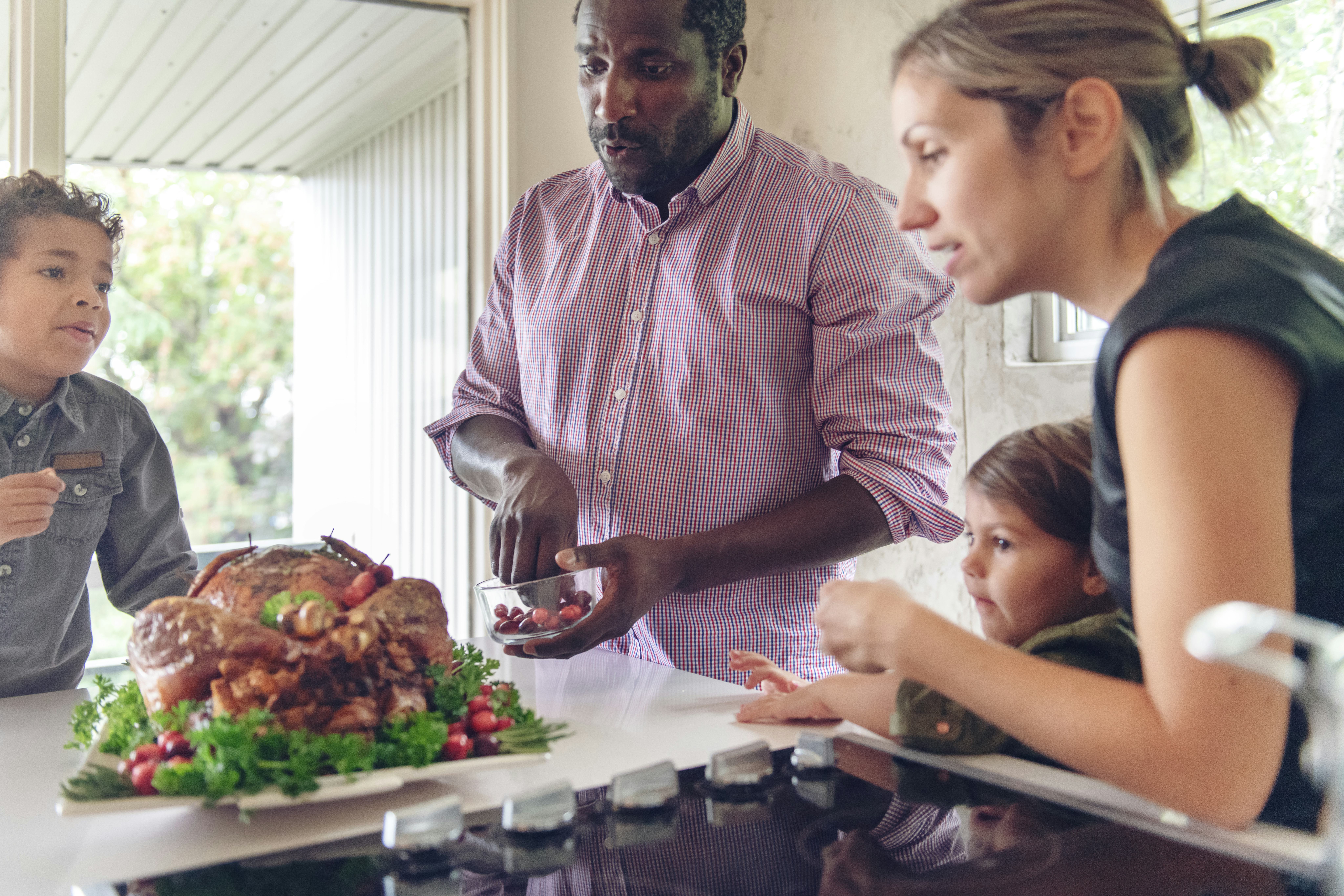 mom and dad serve turkey with their kids