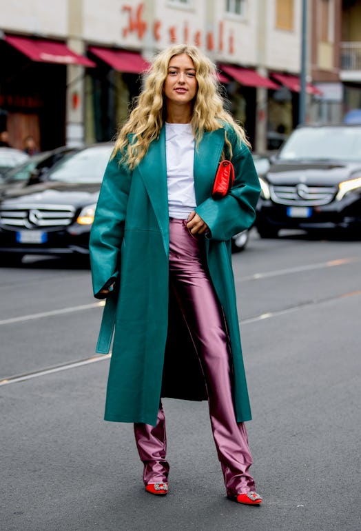 Street style photo of Emili Sindlev wearing a dark teal coat and pink pants at Milan Fashion Week Sp...