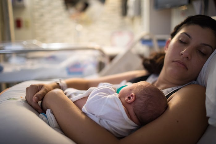 A mother rests with her newborn