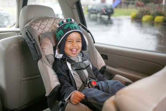 a little boy in a car seat laughing
