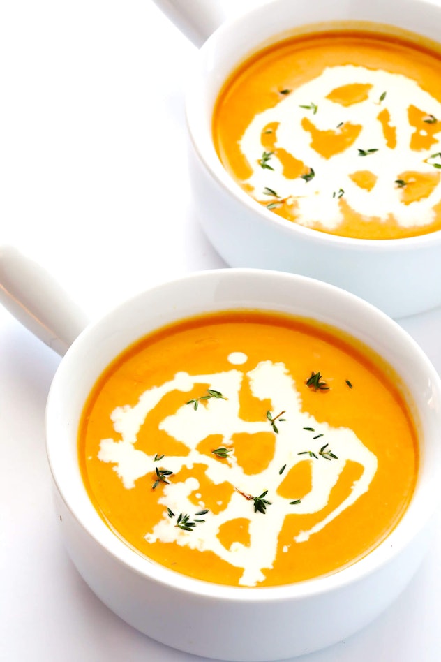 White crocks filled with butternut squash soup.