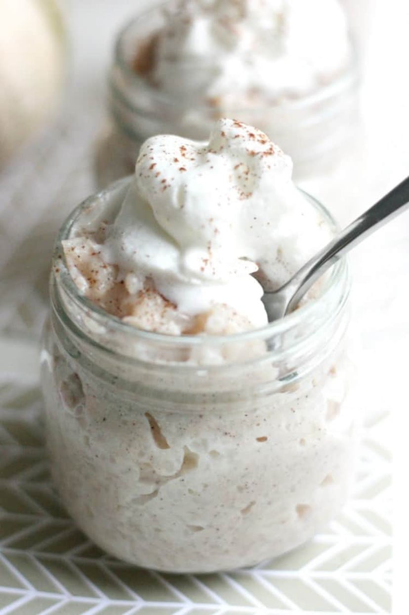 Thanksgiving Desserts: A mason jar of rice pudding topped with whipped cream and pumpkin spice powde...