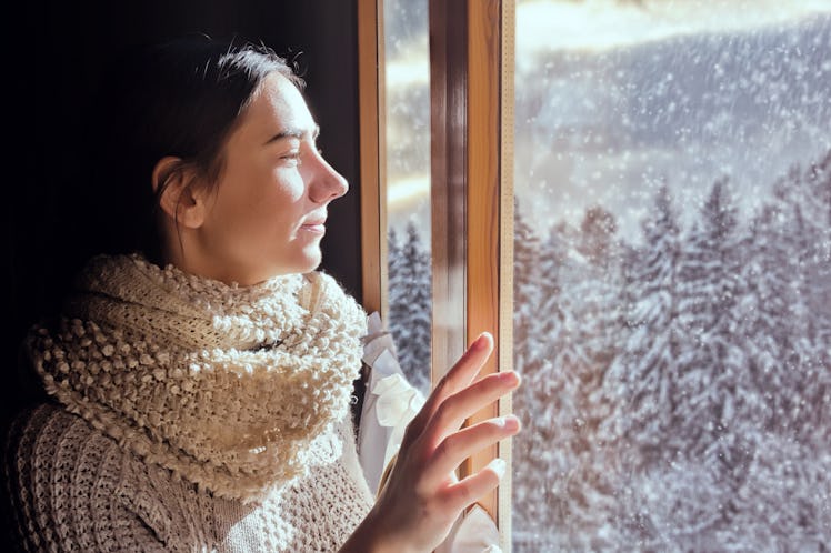 Young woman looking at snowy forest during December full moon