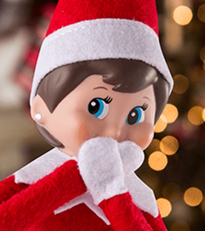 An Elf on the Shelf doll in front of a Christmas tree