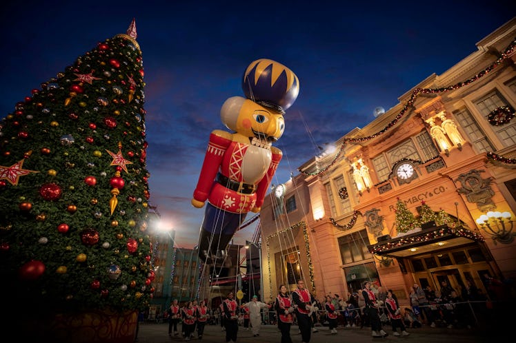 A nutcracker balloons flies over Universal Orlando during the holiday parade featuring Macy's.