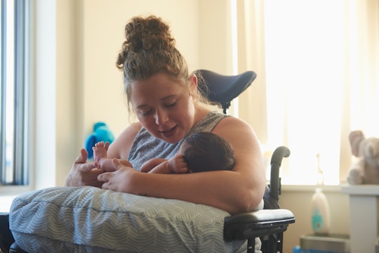 New mom holds baby in her chair