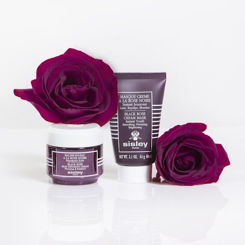Black Rose Friday Precious Oil Set from Sisley Paris next to real black roses