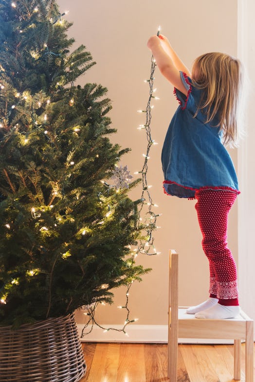 Little girl decorates Christmas tree