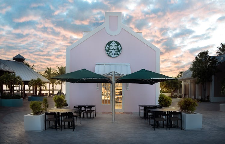 The exterior of Starbucks' Grand Turk store features a patio with green umbrellas and views of the b...