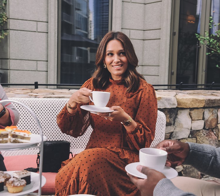A stylish woman holds a cup of tea during Waldorf Astoria Atlanta Buckhead's holiday afternoon tea.