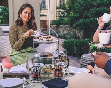 A stylish woman enjoys holiday afternoon tea and food with friends at Waldorf Astoria Atlanta Buckhe...
