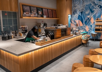 The interior of Starbucks' Grand Turk store has a tropical blue and pink wall and wooden accents.