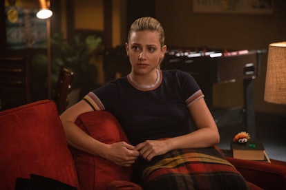Betty sitting on a couch in Riverdale looking worried